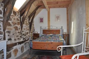 CoubisouにあるGîte Le Couderc de Coubisou, grange rénovéeの石壁のベッドルーム1室