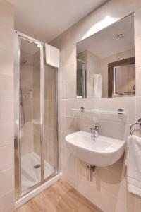 a bathroom with a sink and a shower at Livensa Living Studios Bilbao in Bilbao