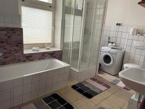 a bathroom with a tub and a washing machine at Wohnen in Loriot’s Wasserstadt mit Kamin in Brandenburg an der Havel