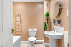 La salle de bains est pourvue de toilettes blanches et d'un lavabo. dans l'établissement River View House, à Lincoln