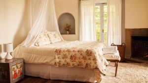 a bedroom with a bed with a canopy and a fireplace at Casa Origen in Pirque