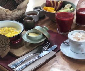 uma mesa de madeira com uma bandeja de pequeno-almoço com alimentos e bebidas em Casa Origen em Pirque