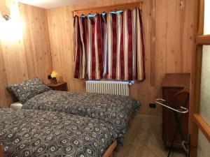 a small bedroom with a bed and a window at Alloggio Kenne, a 200m dagli impianti Monterosaski in Champoluc