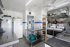 a large kitchen with white appliances in a kitchen at Motel Sunshine Coast in Caloundra