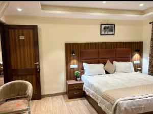 a bedroom with a large bed and a chair at Himalayan view in Shimla