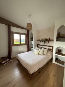 a bedroom with a bed with white sheets and a window at Magnifique chalet en bord de rivière in Saint-Avit-les-Guespières