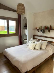 1 dormitorio con 1 cama blanca grande con almohadas en Magnifique chalet en bord de rivière, en Saint-Avit-les-Guespières