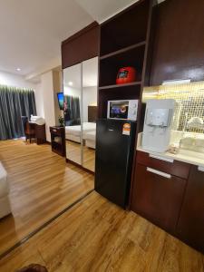 a living room with a black refrigerator in a room at BV3 Studio Type with swimming pool in KK City Centre in Kota Kinabalu