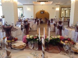 - une table dans une salle de banquet avec des tables et des chaises blanches dans l'établissement Motel Perla Sigheteana, à Sighetu Marmaţiei
