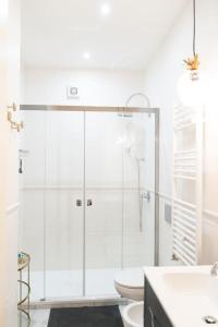 uma casa de banho com uma cabina de duche em vidro e um WC. em Isabella's Luxury Boutique em Corsico