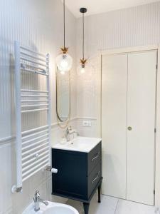 Baño blanco con lavabo y espejo en Isabella's Luxury Boutique en Corsico