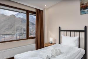 una camera con un letto e una grande finestra di Mountain House Kazbegi a Kazbegi
