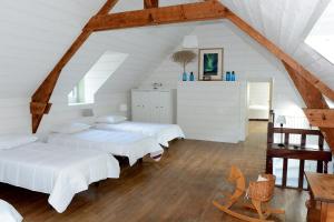 - une chambre mansardée avec 3 lits et une table dans l'établissement KERMANE - Maison 8 personnes Saint-Philibert, à Saint-Philibert
