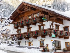 a building covered in snow with christmas decorations at Sportpension Elisabeth in Neustift im Stubaital