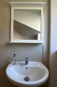 um lavatório branco na casa de banho com um espelho em 2 South Duntulm em Kilmaluag