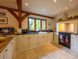 a large kitchen with white cabinets and appliances at The Hayloft in Canterbury