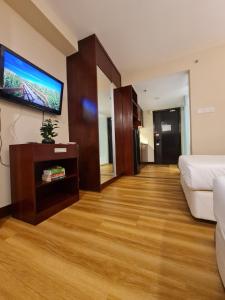 a hotel room with a bed and a flat screen tv at BV3 Studio Type with swimming pool in KK City Centre in Kota Kinabalu