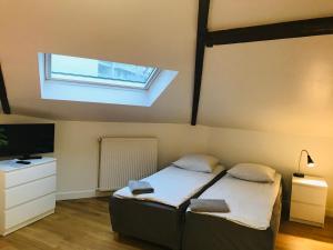 a bedroom with a bed and a television and a window at AparisAppart in Pantin