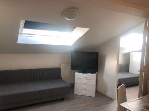 a living room with a couch and a flat screen tv at AparisAppart in Pantin