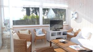 uma sala de estar com um sofá e uma televisão em Cottage maritime avec vue exceptionnelle sur mer em Baden