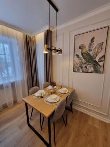 a dining room with a wooden table and chairs at Good Mood Apartment in Klaipėda