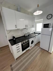 W kuchni znajduje się biała lodówka i kuchenka mikrofalowa. w obiekcie Vista del Mar Guest House w Albufeirze