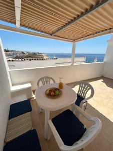 jadalnia ze stołem i krzesłami oraz oceanem w obiekcie Vista del Mar Guest House w Albufeirze