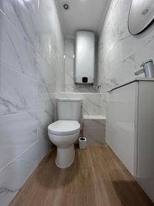 biała łazienka z toaletą i umywalką w obiekcie Vista del Mar Guest House w Albufeirze