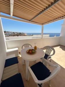 stolik i krzesła w pokoju z widokiem na ocean w obiekcie Vista del Mar Guest House w Albufeirze