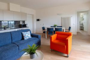 sala de estar con sofá azul y silla naranja en Appartamenti Tre Fontane, en Roma