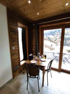 een eetkamer met een tafel en stoelen en een groot raam bij Grand Studio Val Cenis in Lanslebourg-Mont-Cenis