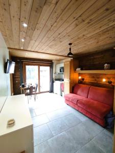 a living room with a red couch and a table at Grand Studio Val Cenis in Lanslebourg-Mont-Cenis