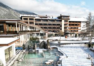 un complexe dans la neige avec une piscine dans l'établissement Rieser Achensee Resort, à Pertisau