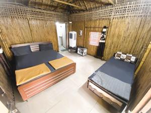 a room with two beds and a tv in it at Wilderness Camp 200mtr from Devaliya Park in Sasan Gir