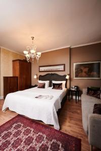 Un dormitorio con una gran cama blanca y una lámpara de araña. en Faik Pasha Hotels Special Category Beyoglu Istanbul, en Estambul