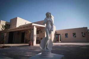 Una statua di una donna in piedi di fronte a un edificio di Villa Stratos Corfu -private pool and hot tub a Città di Corfù
