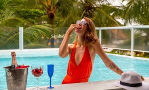 une femme en robe rouge parlant sur un téléphone portable dans l'établissement Pousada Sambass, à Morro de São Paulo 61 autres photos