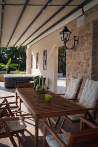 コルフ・タウンにあるVilla Stratos Corfu -private pool and hot tubの木製テーブルと椅子付きのパティオ