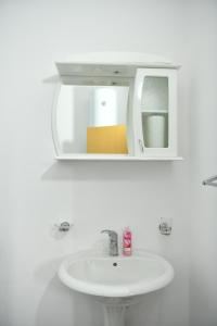 a bathroom with a white sink and a mirror at Apartmani swiss Gold in Priboj