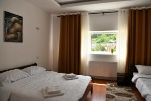a hotel room with a bed and a window at Apartmani swiss Gold in Priboj