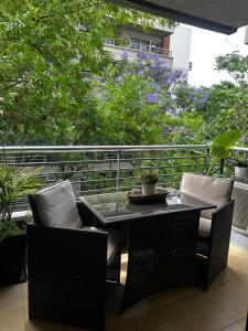 un tavolo e sedie su un balcone alberato di MINIMO DE RESERVA 3 NOCHES Hermoso Monoambiente en Belgrano Buenos Aires a Buenos Aires
