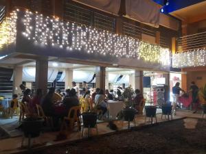 LUMBAYAN BEACH RESORT في Dawis: مجموعة من الناس يجلسون في مطعم مع أضواء