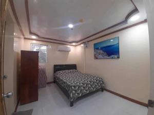 a small bedroom with a bed in a room at LUMBAYAN BEACH RESORT in Dawis