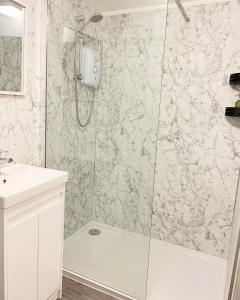 a bathroom with a shower with a tub and a sink at The Traveller's B&B in Louth