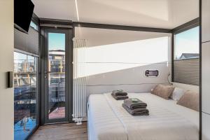 a bedroom with a bed and a large window at Charming Tiny Houseboat Escape Near Amsterdam in Kortenhoef