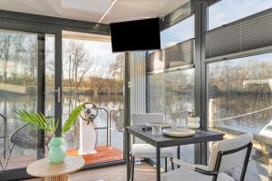 a dining room with a table and a view of the water at Charming Tiny Houseboat Escape Near Amsterdam in Kortenhoef