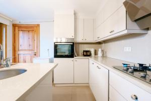 a white kitchen with white cabinets and a sink at House with Garden and Bosphorus View in Kuzguncuk in Istanbul