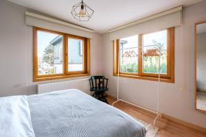 a bedroom with a bed and windows and a chair at House with Garden and Bosphorus View in Kuzguncuk in Istanbul