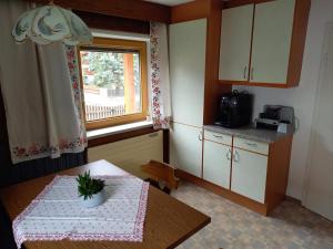 a small kitchen with a table and a window at Ferienwohnung Familie Brenner in Haiming