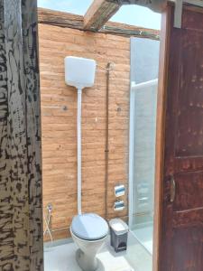 a bathroom with a toilet and a shower at Hospedagem Pé de Serra in Botucatu